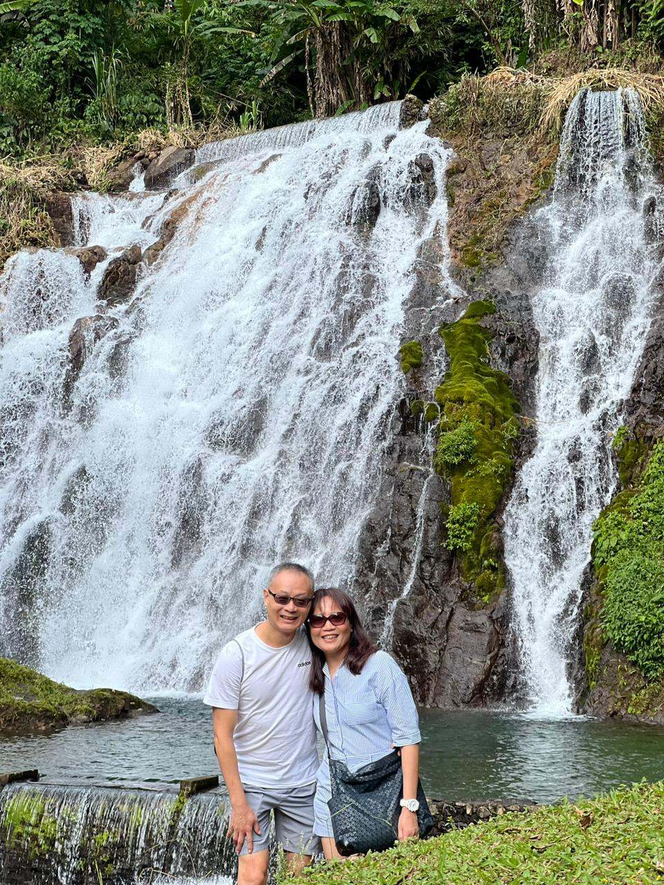 Couple in front of a wide waterfall