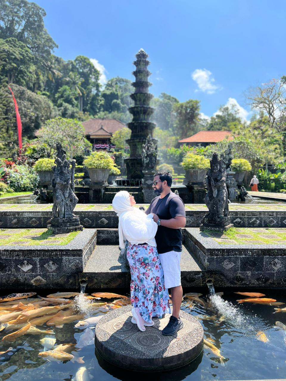 Couple at Tirta Gangga with koi fish and fountain