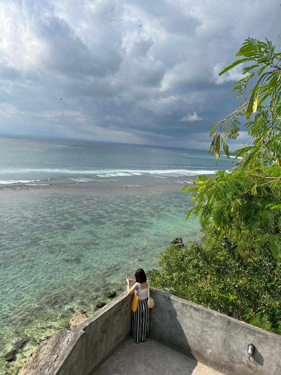 Guest looking out at the ocean from a clifftop