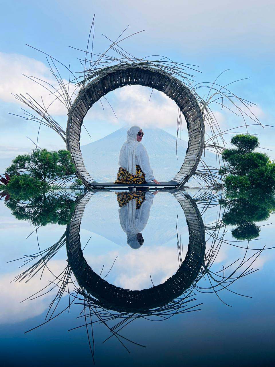 Guest in a woven ring frame reflected in water