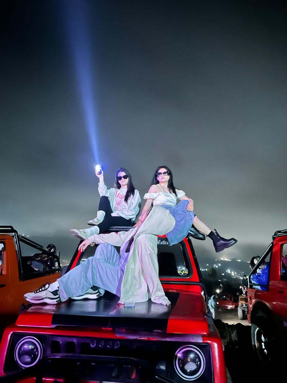 Guests on a red jeep with a light beam at night, Mount Batur