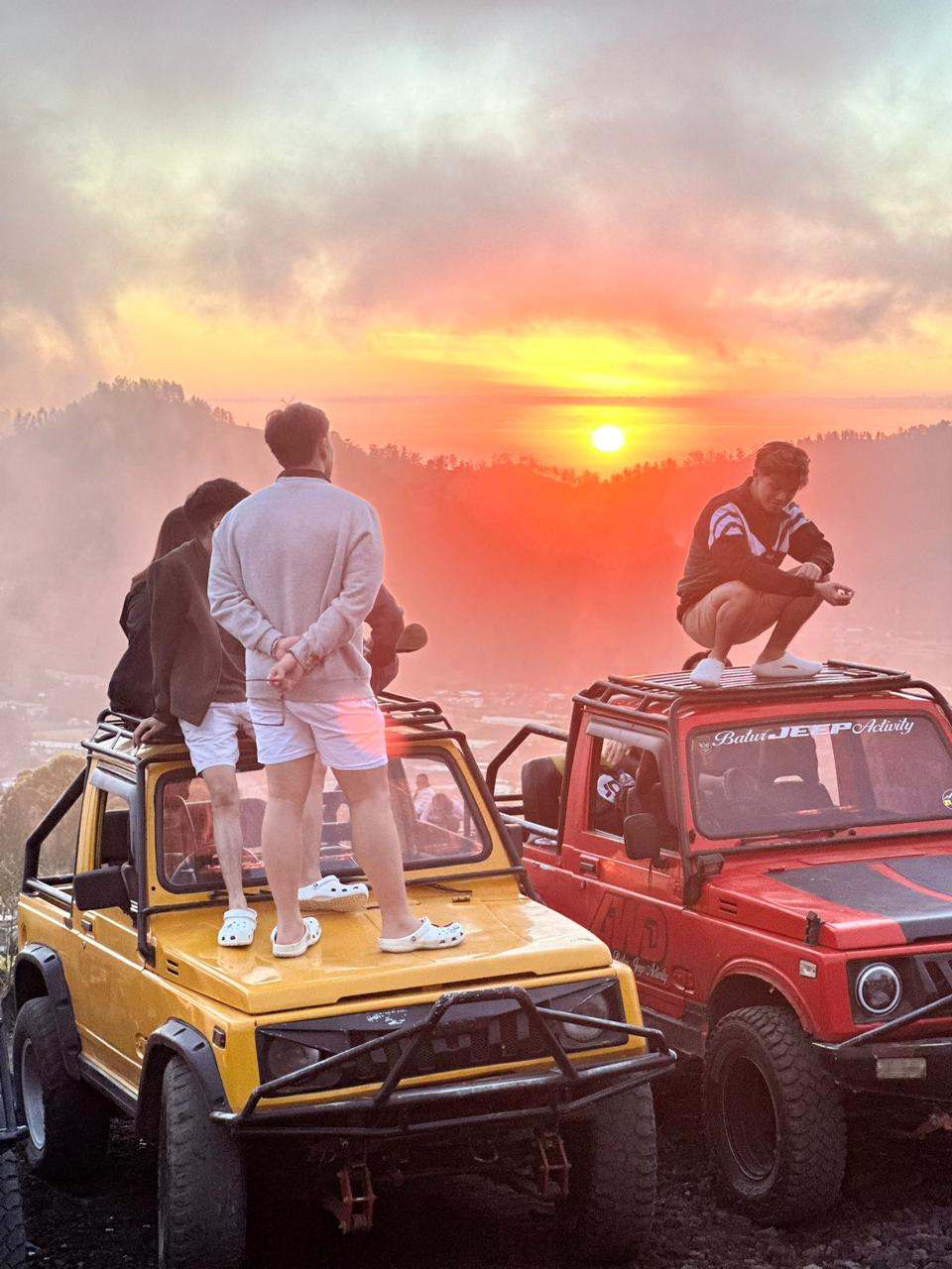 Guests on yellow and red jeeps at sunrise, Mount Batur