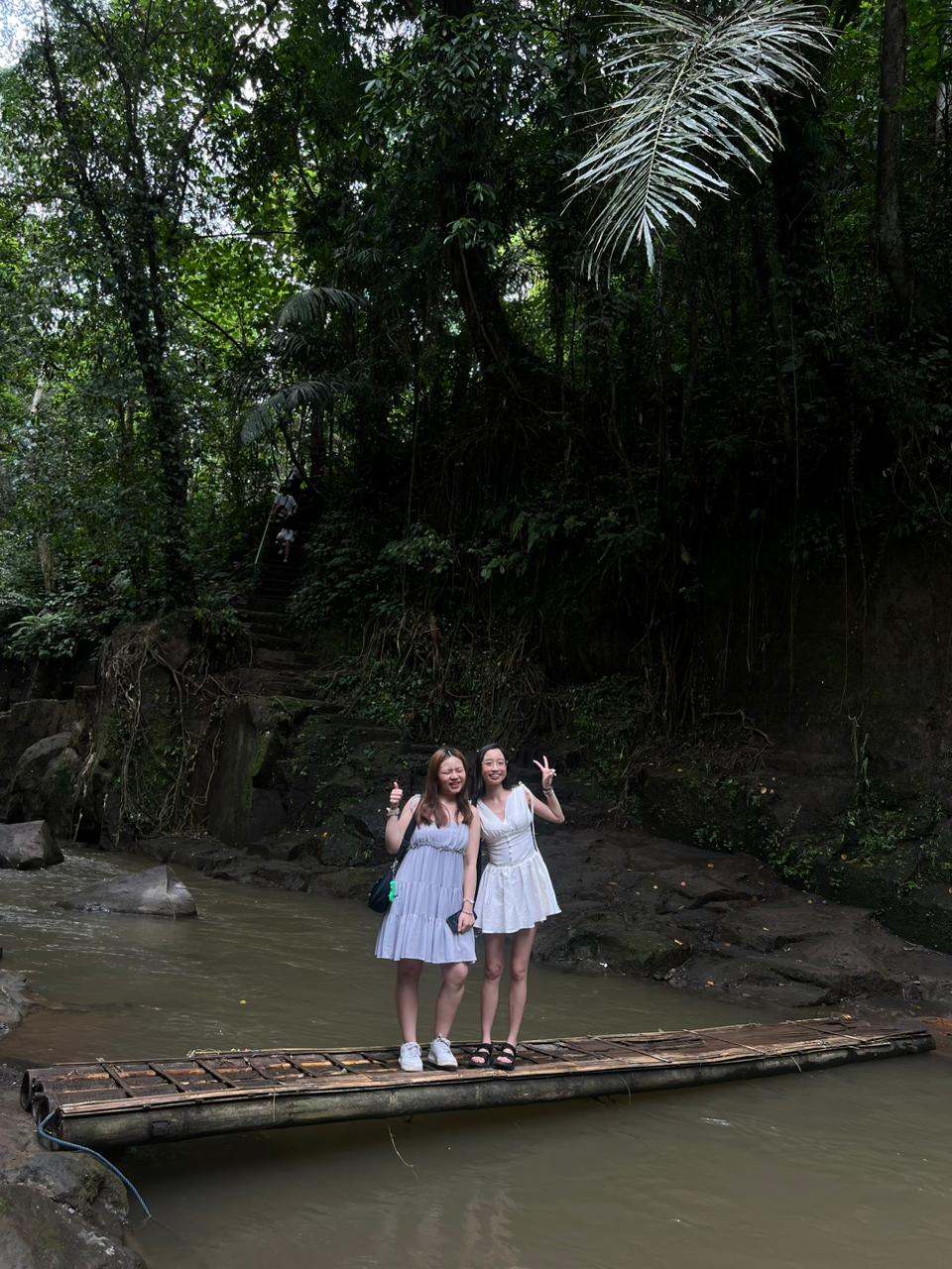 Two guests on a bamboo raft at a jungle river